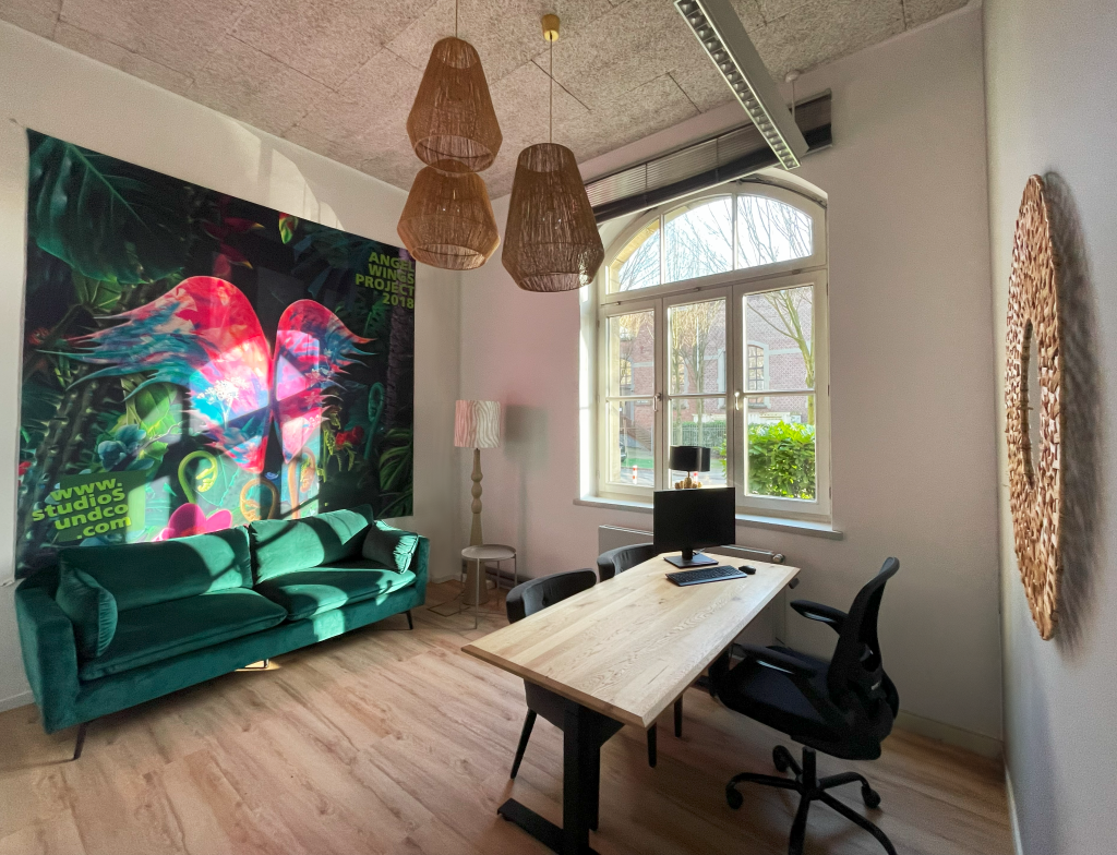 Helles Büro mit einem großen Tisch und Stühlen, einladend für produktive Gespräche und Teamarbeit